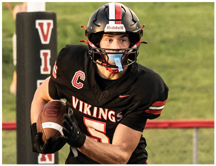 A football player running with a football. Description generated by AI