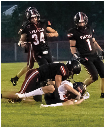 A group of football players on a field. Description generated by AI