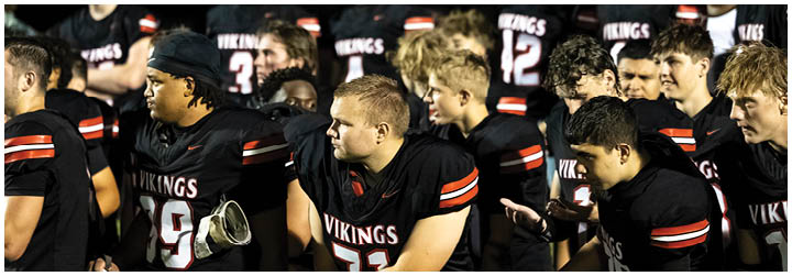 A group of people wearing black jerseys with the word Vikings on the front. Description generated by AI
