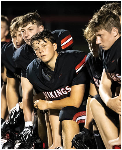 A group of young men wearing black jerseys. Description generated by AI
