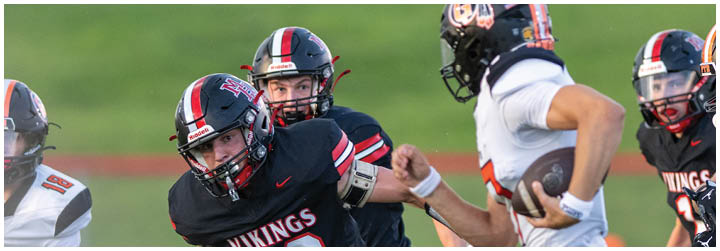 A football player wearing a black jersey with the number 22 on it. Description generated by AI