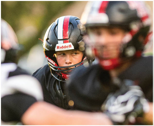 A football player wearing a black helmet. Description generated by AI