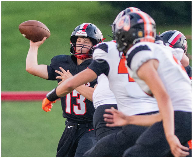 A football player wearing a black jersey with the number 13 on it. Description generated by AI