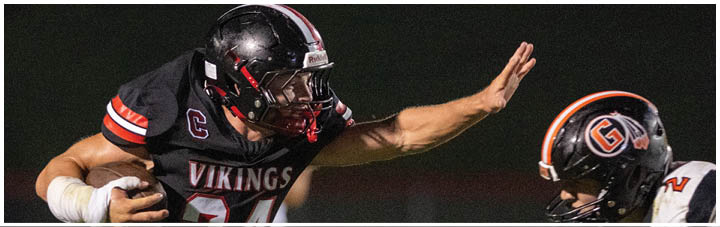 A football player wearing a black jersey with the number 34 on it. Description generated by AI