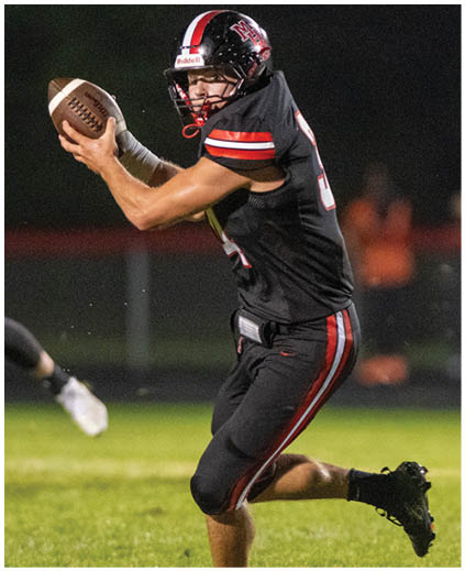 A football player in a black jersey with the number 13 on it. Description generated by AI