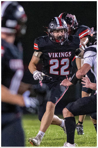 A football player wearing a black jersey with the number 22 on it. Description generated by AI