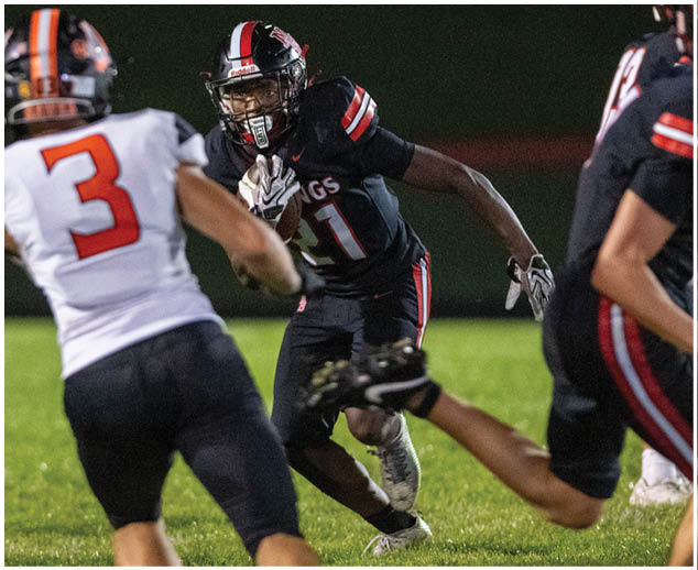 A football player wearing a black jersey with the number 17 running on the field. Description generated by AI