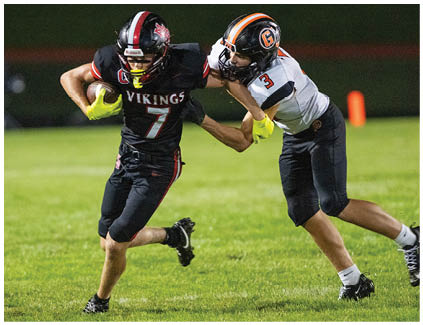 A football player wearing a black jersey with the number 7 on it. Description generated by AI