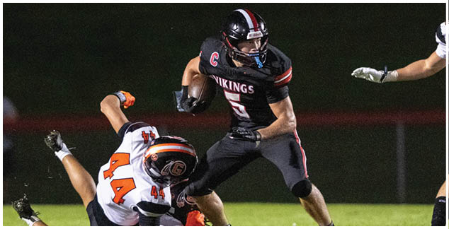 A football player wearing a black jersey with the number 7 on it. Description generated by AI
