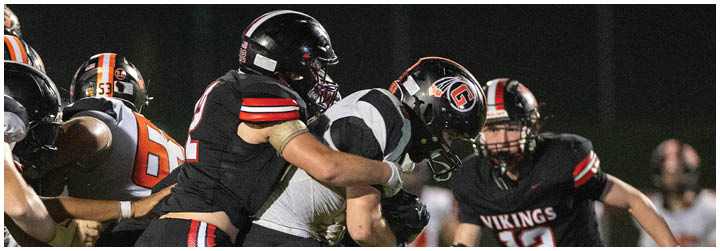 A group of football players in black and orange uniforms. Description generated by AI