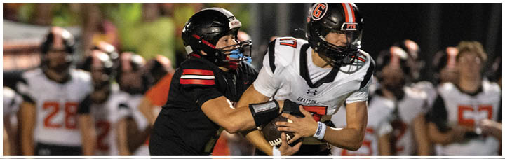 A football player in a black jersey is tackling another player. Description generated by AI