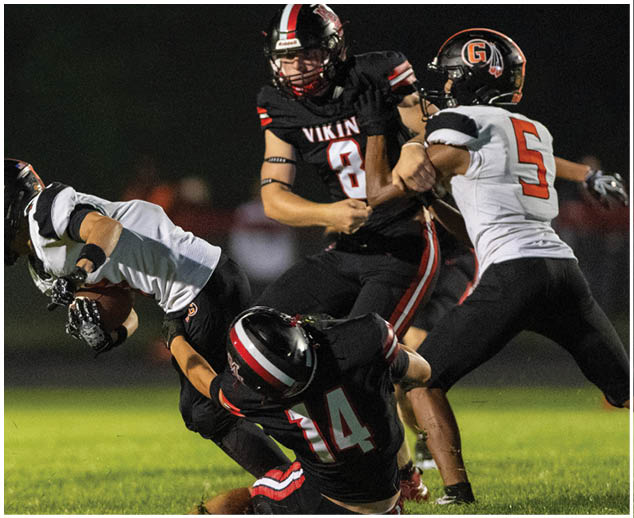 A football player is tackled to the ground. Description generated by AI