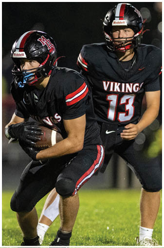 A football player in a black jersey with the number 13 on it. Description generated by AI
