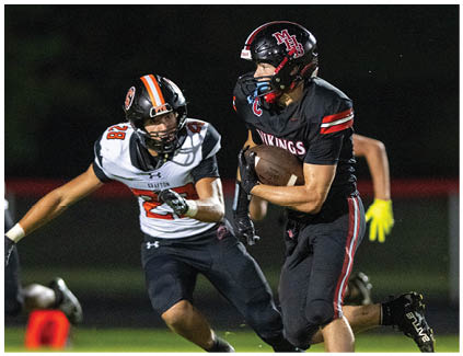 A football player in a black jersey with the number 22 on it. Description generated by AI