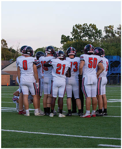 A group of football players on the field. Description generated by AI
