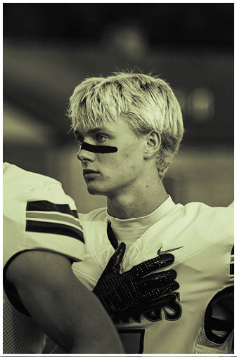 A young man with blonde hair and a black bandana on his head. Description generated by AI