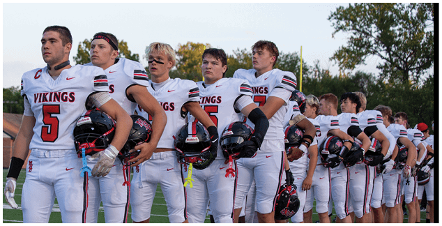 A group of football players wearing white and red uniforms. Description generated by AI