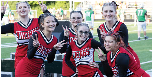 A group of cheerleaders in red and white uniforms. Description generated by AI