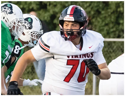 A football player wearing a white jersey with the number 70 on it. Description generated by AI