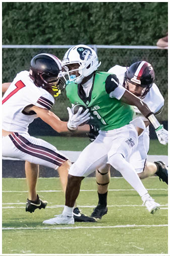 A football player in a green jersey is running with the ball. Description generated by AI