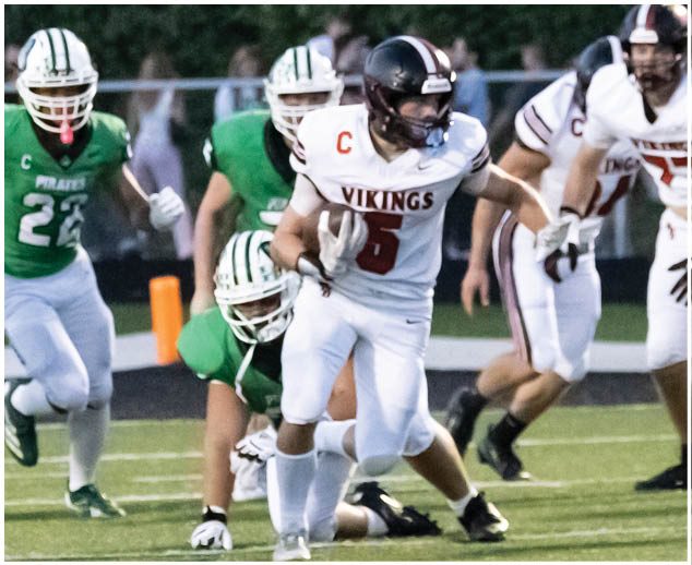 A football player in a white jersey with the number 5 on it. Description generated by AI