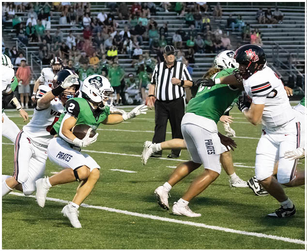 A football player in a green jersey is running with the ball. Description generated by AI
