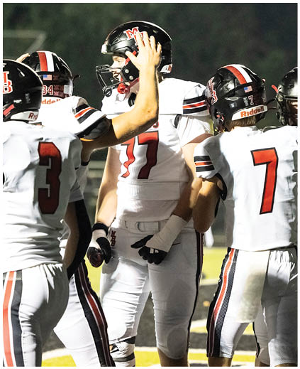 A group of football players wearing white and black uniforms. Description generated by AI