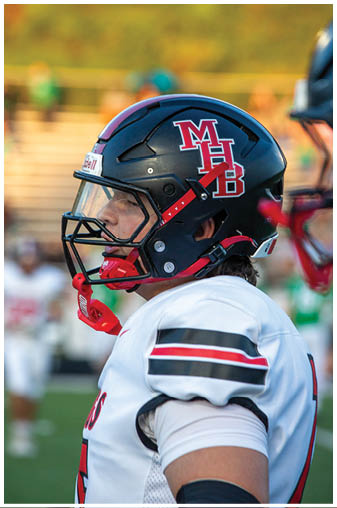 A football player wearing a helmet with the letters M and B on it. Description generated by AI