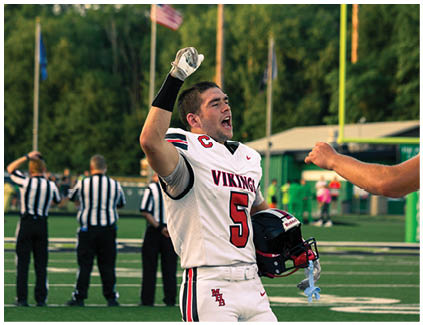 A man wearing a white jersey with the number 5 on it. Description generated by AI
