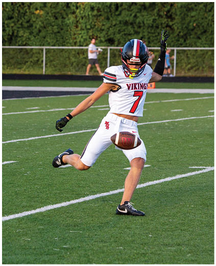 A football player wearing a white jersey with the number 7 on it. Description generated by AI