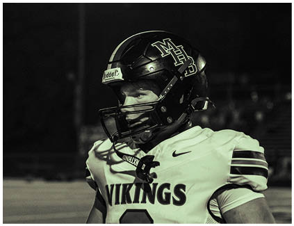 A football player wearing a helmet with the word Vikings on it. Description generated by AI