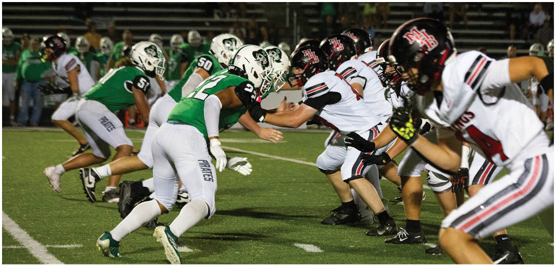 A football game is being played with a group of men in green and white uniforms. Description generated by AI