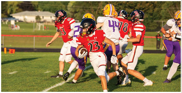 A football player in a red jersey is running with the ball. Description generated by AI