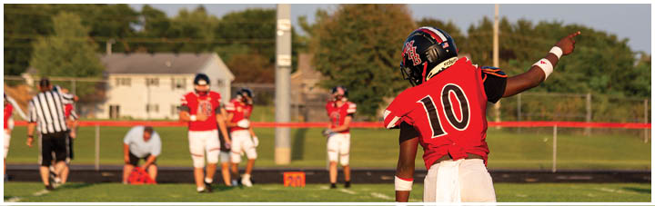 A football player wearing a red jersey with the number 10 on it. Description generated by AI