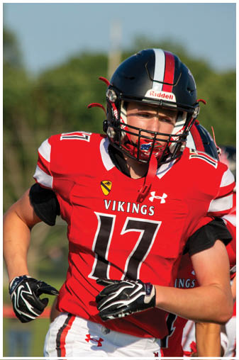 A football player wearing a red jersey with the number 17 on it. Description generated by AI