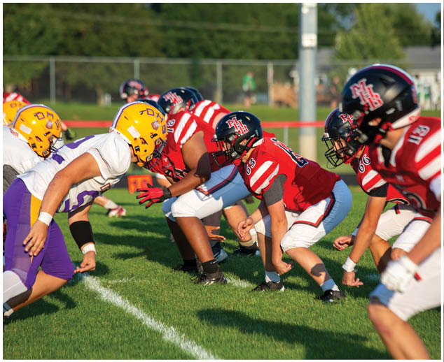 A group of football players in red and yellow uniforms. Description generated by AI