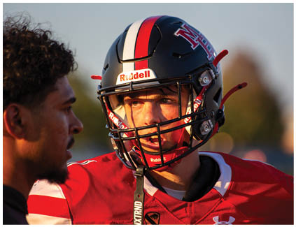 A football player wearing a red and white uniform. Description generated by AI