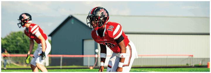 Two football players on a field. Description generated by AI