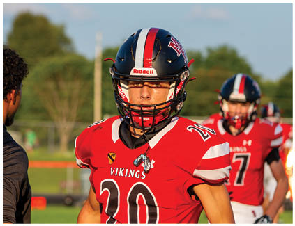 A football player wearing a red jersey with the number 20 on it. Description generated by AI