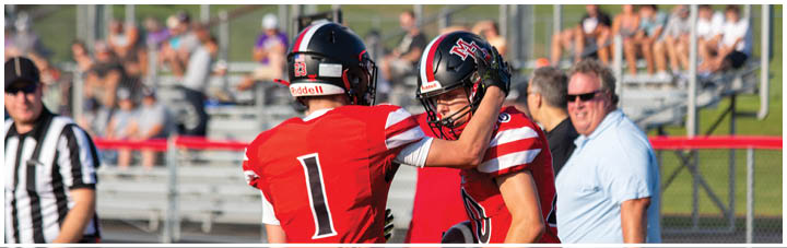 Two football players are hugging each other. Description generated by AI