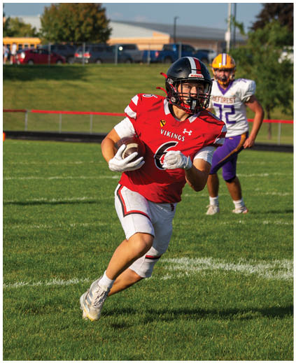 A football player running with a ball. Description generated by AI