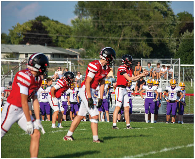 A group of football players on a field. Description generated by AI