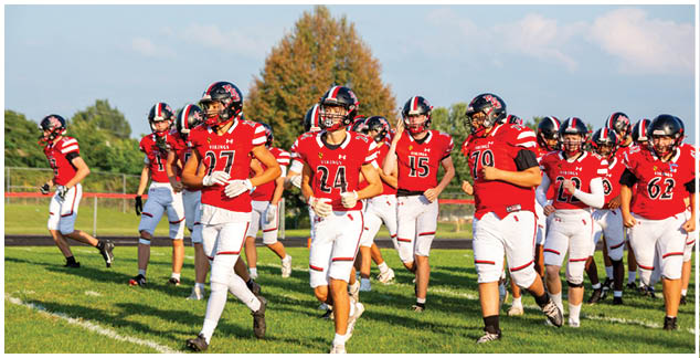 A group of football players wearing red and white uniforms. Description generated by AI