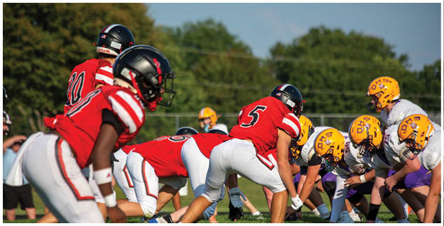 A group of football players in red and yellow uniforms. Description generated by AI