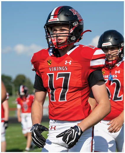 A football player wearing a red and white jersey with the number 17 on it. Description generated by AI