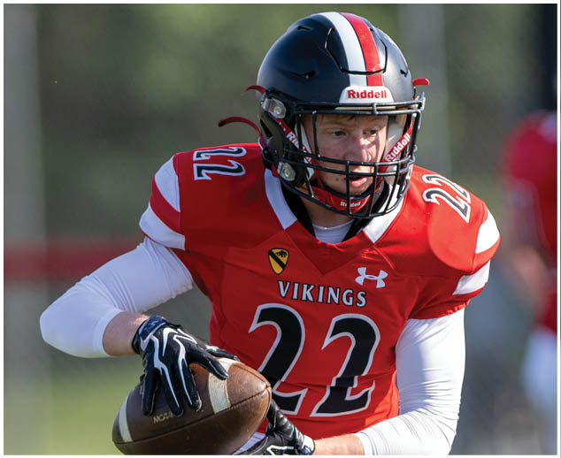 A football player wearing a red and white jersey with the number 22 on it. Description generated by AI