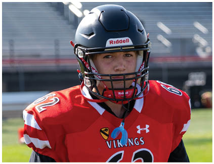 A football player wearing a red and black jersey with the number 62 on it. Description generated by AI