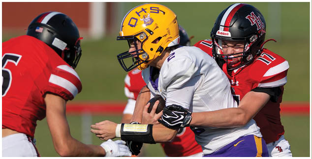 A football player in a red jersey is tackled by a player in a white jersey. Description generated by AI