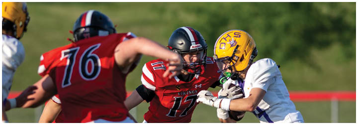 A football player in a red jersey is running with the ball. Description generated by AI