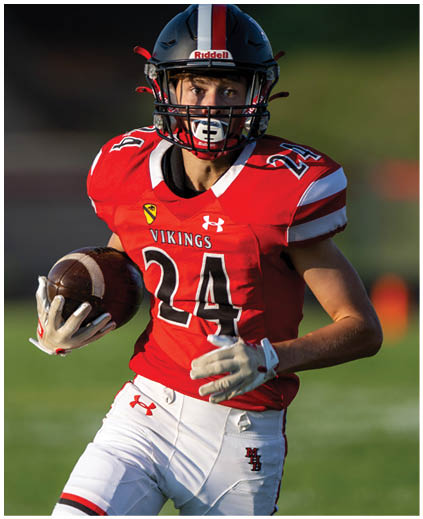 A football player wearing a red and black jersey with the number 24. Description generated by AI